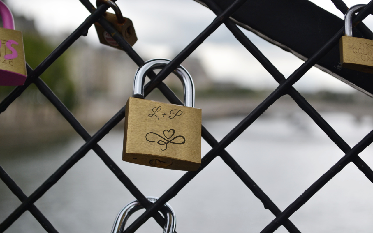 zámek s gravírováním zavěšený na pletivu